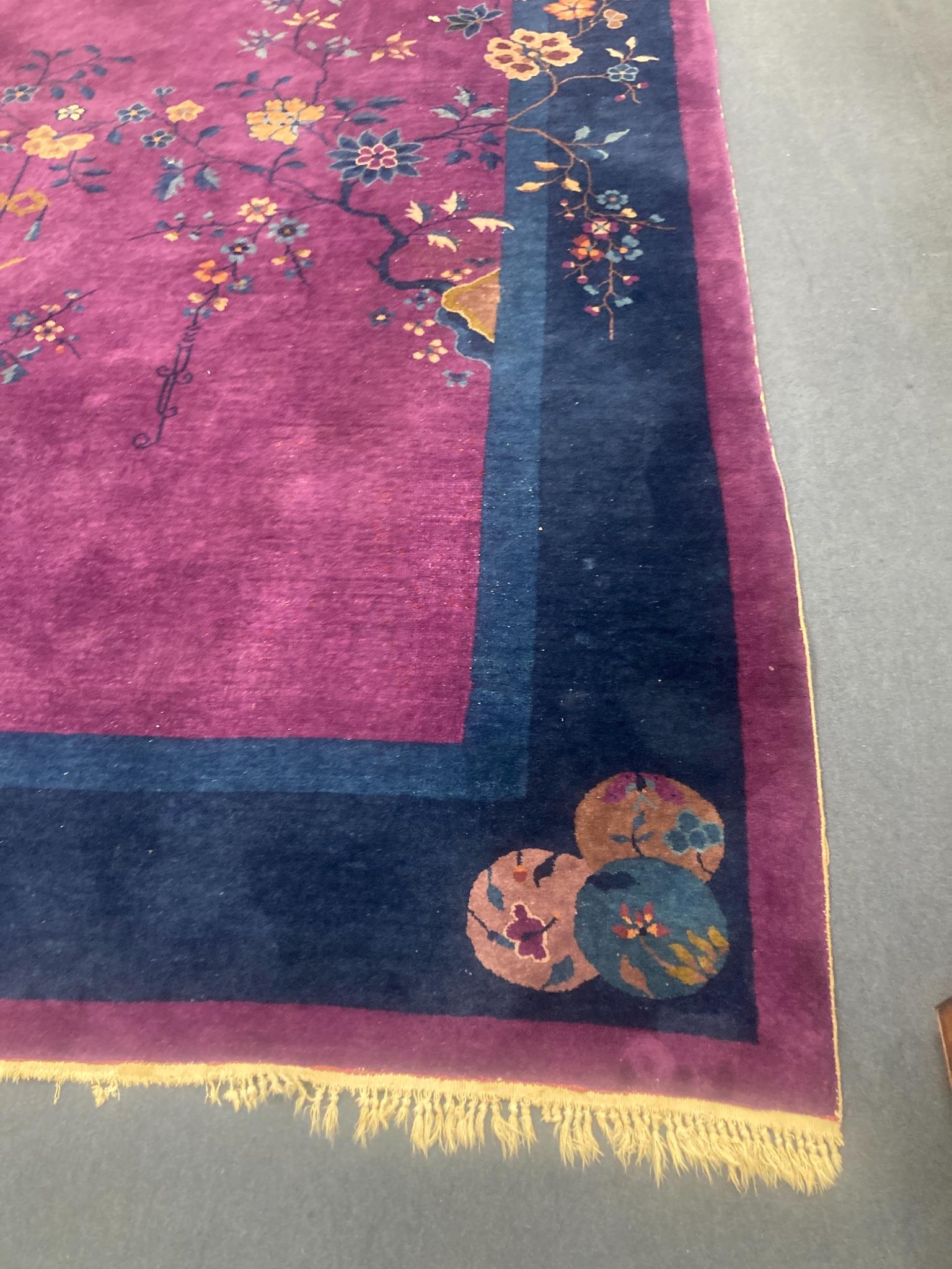 A large purple ground Chinese wool carpet, 342 x 276cm